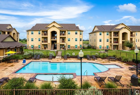 A large building with a pool in front of it.