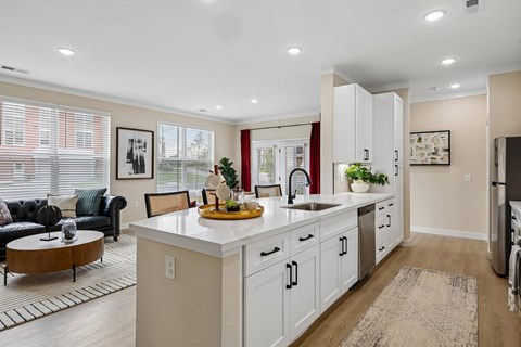A kitchen with white cabinets and a wooden island.
