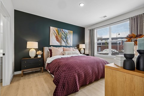 A bedroom with a large bed and a painting on the wall.