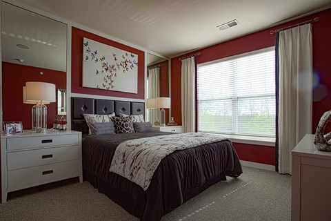 A bedroom with a large bed and a painting on the wall.