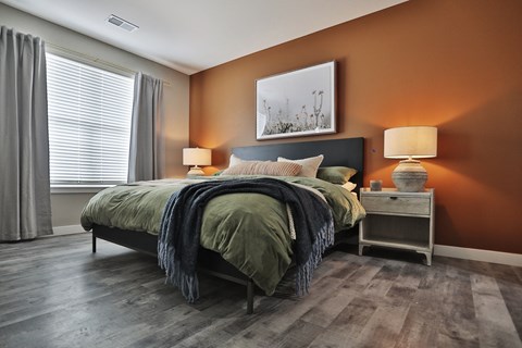 A bedroom with a bed, nightstand, and lamp.