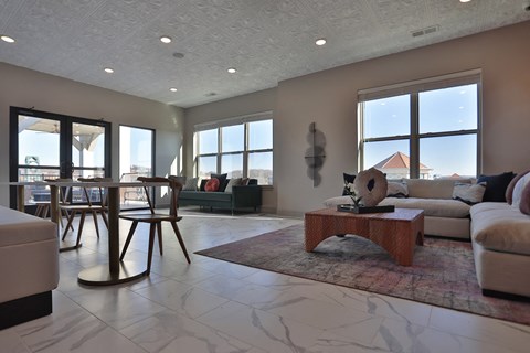A living room with a large window and a view of a house.