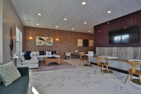 A living room with a couch, chairs, and a television.