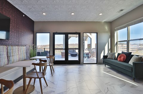 A living room with a couch, chairs, and a television.