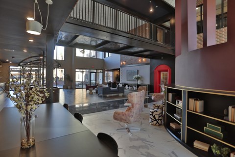 A modern interior with a red door and a black bookshelf.
