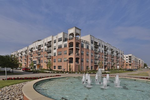 A large apartment complex with a fountain in front.