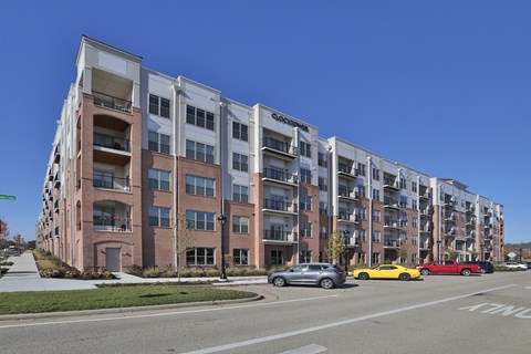 A modern apartment building with cars parked in front.