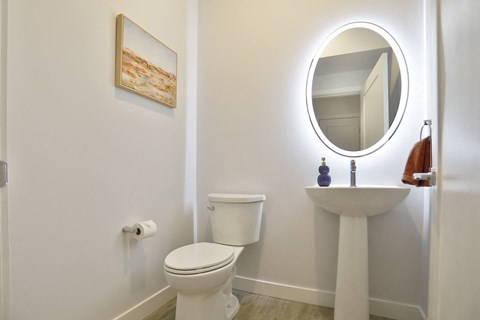 a white bathroom with a toilet sink and a mirror