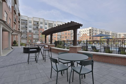 A patio with a table and chairs and a pergola.