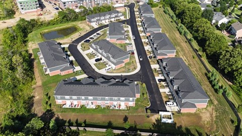 A bird's eye view of a residential area with houses and a roundabout.