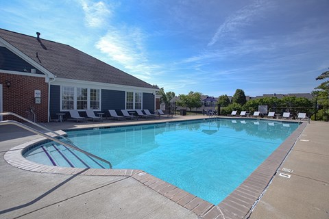 A large outdoor swimming pool with a building next to it.