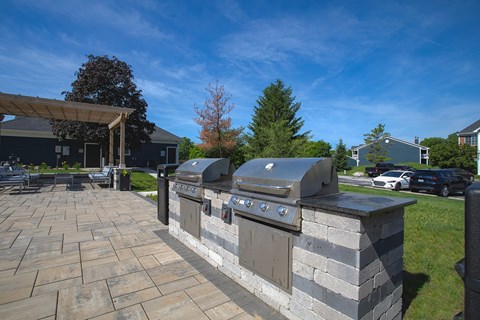 A stone patio with a built-in BBQ grill.