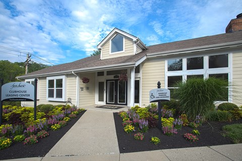 The front of a building with a sign that says "Foxhills Clubhouse Leasing Center.".