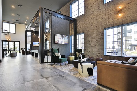 a living room with a brick wall and large windows