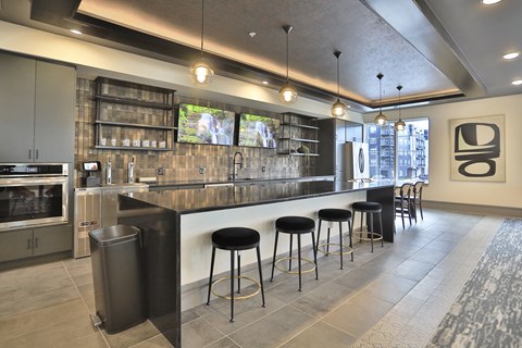 a large kitchen with a bar and stools