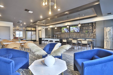 a clubhouse with blue chairs and tables and a bar