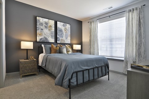 a bedroom with a bed and a large window