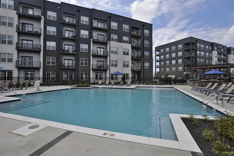 A large swimming pool in front of apartment buildings.
