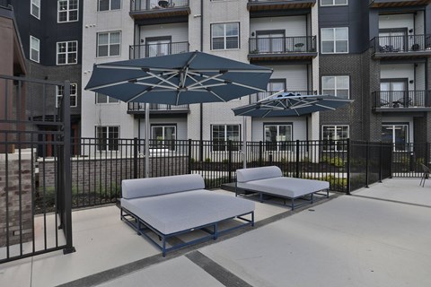 A patio with a black metal fence and a blue and white bench.