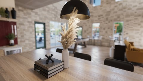 A table with a stack of books and a vase with a plant on top.
