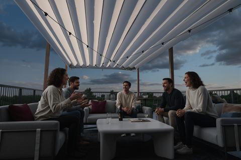 Four people sitting on a patio under a white canopy.