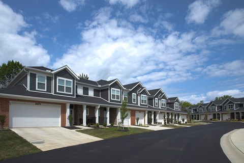 A row of houses with garages and driveways.