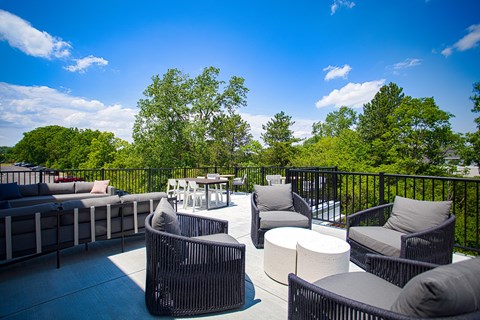 A patio with black wicker furniture and a table.