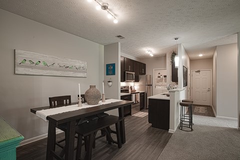 A kitchen with a dining table and chairs.