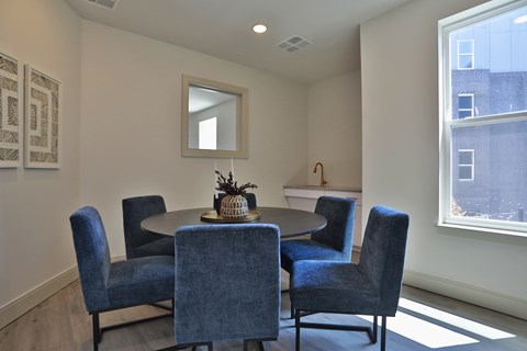 A dining room with a round table and six chairs.