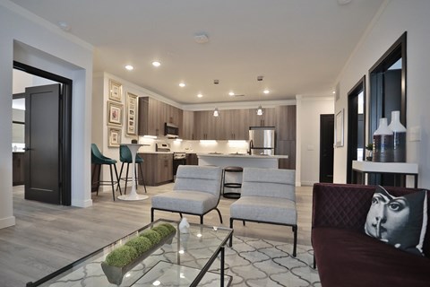 A modern living room with a glass coffee table and a couch with a pillow on it.