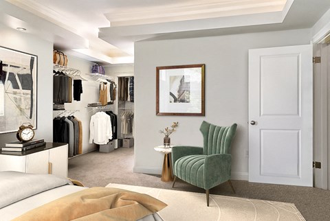 A bedroom with a green chair and a white door.