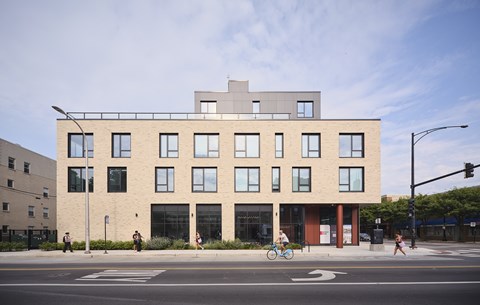 A modern building with a flat roof and a balcony on the second floor.