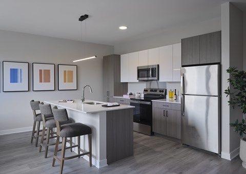 A modern kitchen with a white island and stainless steel appliances.