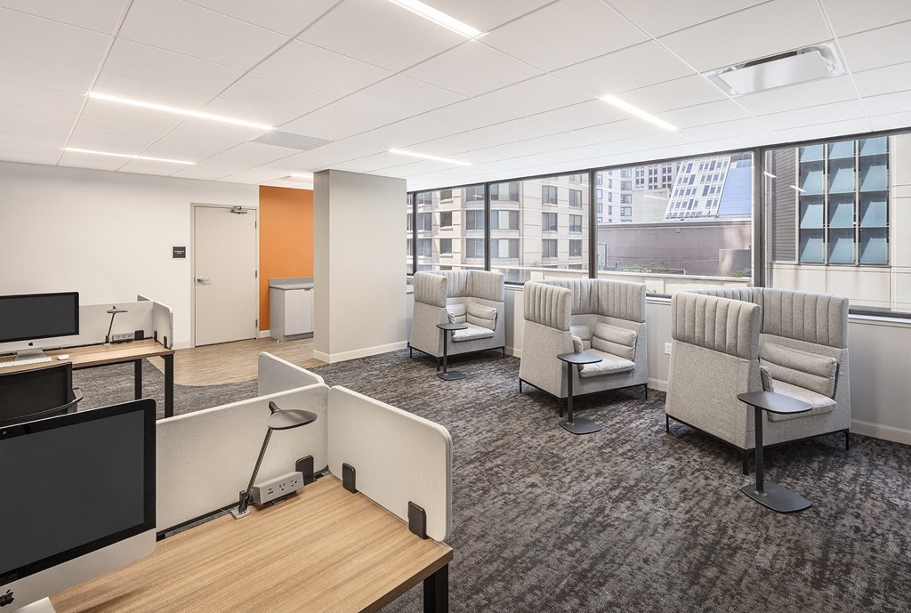 a lounge area with chairs and tables and a tv