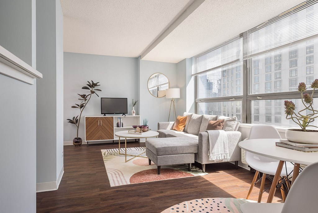 A living room with a grey couch, a white coffee table, and a TV on a wooden cabinet.