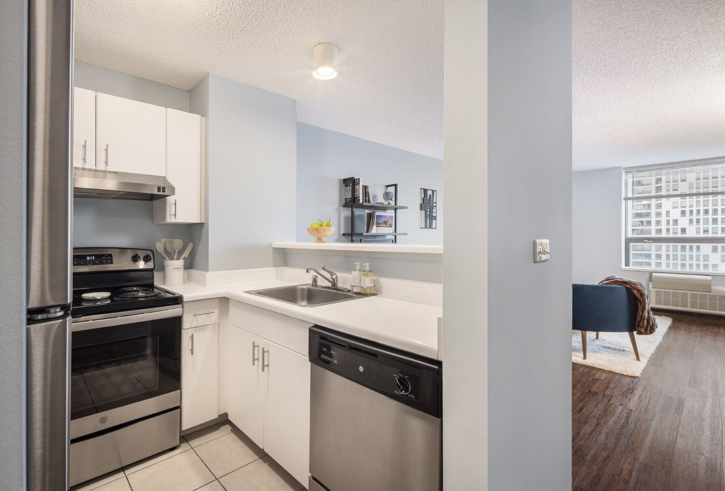 A modern kitchen with stainless steel appliances and white cabinets.