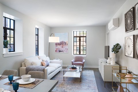 A living room with a grey couch, a red chair, a coffee table, and a rug.