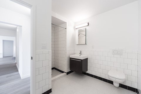A white bathroom with a toilet, sink, and mirror.
