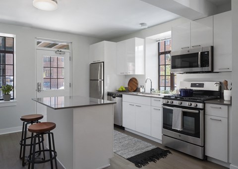 A modern kitchen with white cabinets and stainless steel appliances.