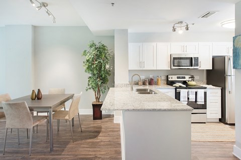 A modern kitchen with a dining table and chairs.