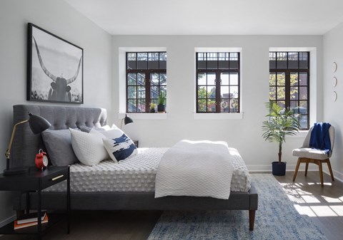 a bedroom with a bed and three windows