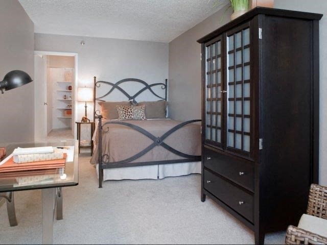 a bedroom with a bed and a cabinet