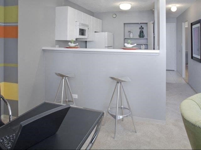 a kitchen with a bar and two stools