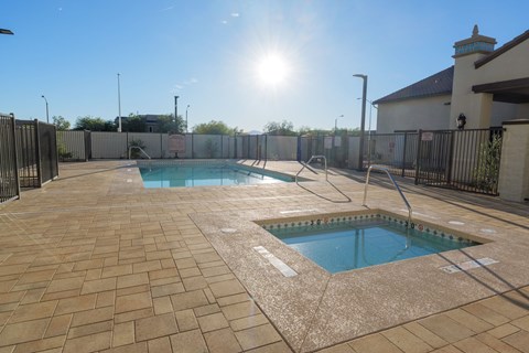 A sunny day at the pool with a fence surrounding the area.