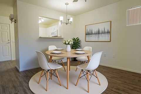 A dining room with a round table and chairs.