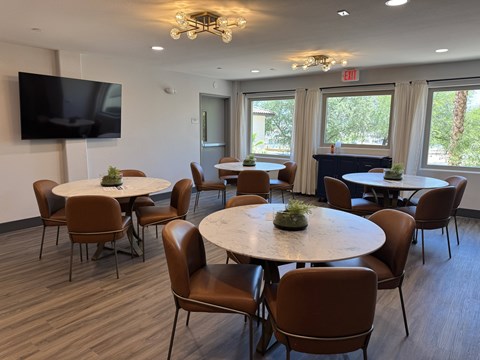A conference room with a round table and chairs.
