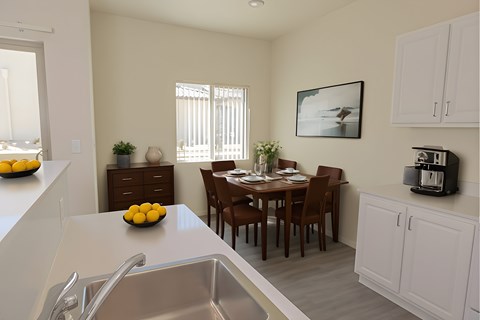 A kitchen with a dining table and chairs.