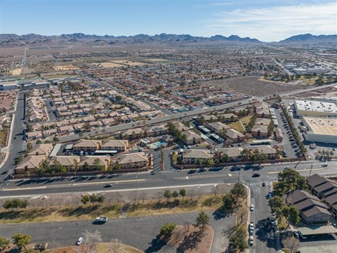 A bird's eye view of a residential area with houses, roads, and vehicles.
