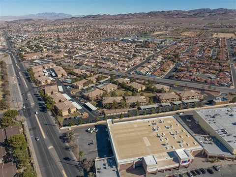 A large open parking lot is surrounded by apartment buildings.