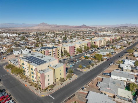 A view of a city with a road running through it and a mountain in the background.